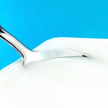 dairy and rustic farm food styled concept - natural yogurt on blue background, elegant visuals