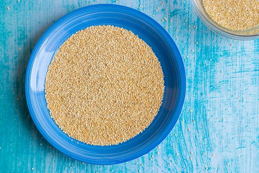 Uncooked quinoa grains inside blue plate