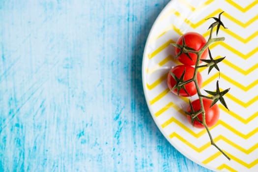 Cherry tomatoes on yellow striped plate