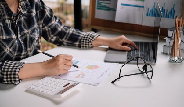 Consult financial concept. Business man pointing at papwework and using laptop computer.