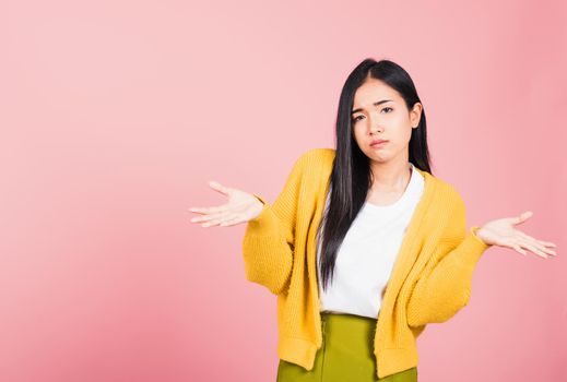 Asian portrait beautiful cute young woman teen shrugging with spread hands she shocked dont understand and confused studio shot isolated on pink background, female doubt with copy space