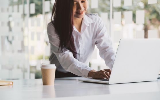 Close up woman using laptop computer on workplace.