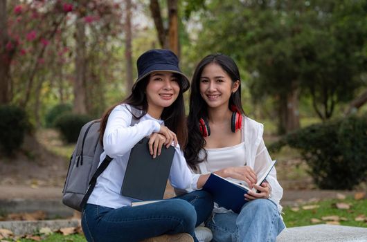 Shot of two Asian college student or University look at the camera at park.