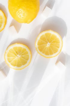 Sliced lemon on a white background . Lemon layout. Sliced fruit. Yellow color. White background. Light and shadow. Citrus. Healthy food. Copy space