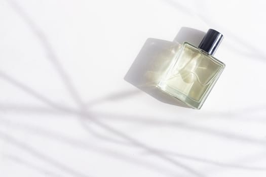 Perfume on a white background with shadows . The choice of perfume. Aromatherapy. Smell. A bottle of perfume. White background. Light and shadows . Copy space