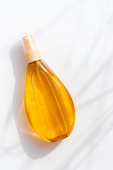 Suntan oil on a white background .Shadows and light. Protect your skin from the sun. A proper and even tan. Copy space