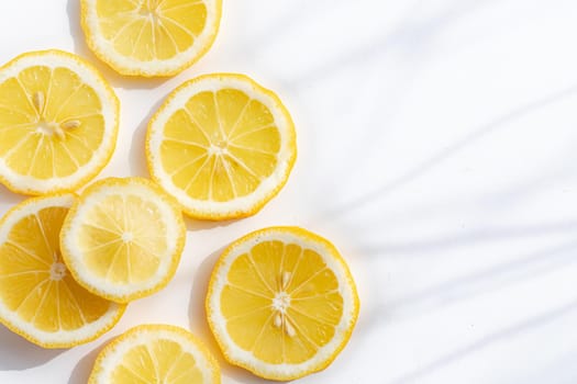Sliced lemon on a white background . Lemon layout. Sliced fruit. Yellow color. White background. Light and shadow. Citrus. Healthy food. Copy space