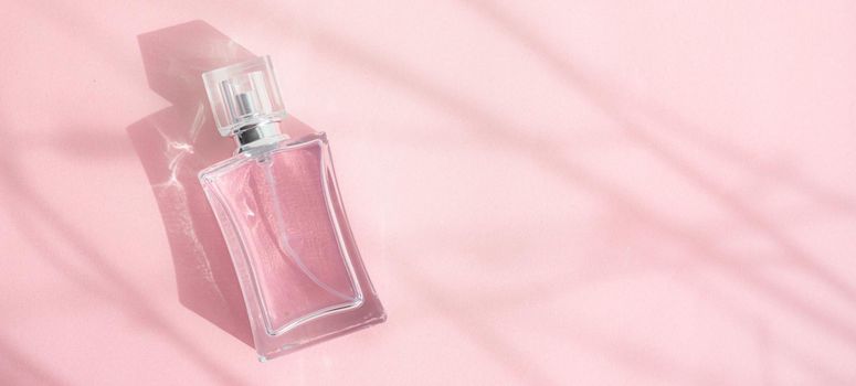 A bottle of perfume on a pink background . Pink perfume. Smell. Aromatherapy. An article with a place for the text about the choice of perfume fragrance. Light and shadows. Naturalness . Copy space