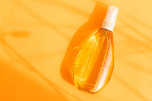 Suntan oil on an orange background .Shadows and light. Protect your skin from the sun. A proper and even tan. Copy space