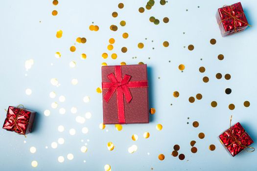 Red confetti gift . Red gift layout on top. Confetti is scattered. New year and Christmas. Valentine's day. Holiday. Article about gifts