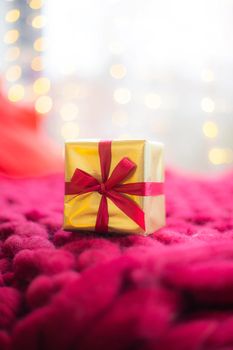 Gift on a blanket new year . a festive atmosphere. Article about choosing a gift. Bokeh lights. Garland defocus. Gift on the background of a garland . copy space