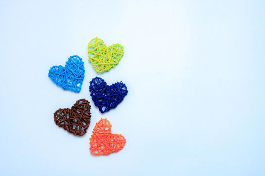 Colored hearts on a blue background . Hearts made from rattan . Holiday. Valentine's Day. Holiday of mothers. Copy space. Banner with a place for the text. Article about the Valentine's day. Blue background