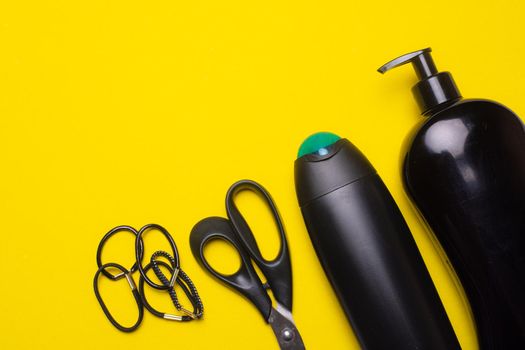 Black shampoo on the background of copyspace. A bottle of shampoo. Yellow background. Article about the beauty industry. Shampoo on a yellow background