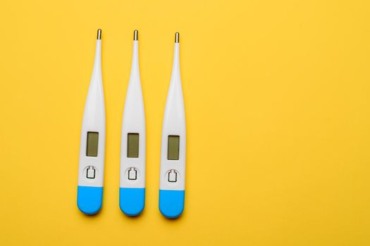 Electronic thermometers . Electronic thermometer on a yellow background. Temperature measurement. Safe thermometer. Modern medical equipment. Science and medicine. Article about safe thermometers. Technologies. Yellow background . Copy space