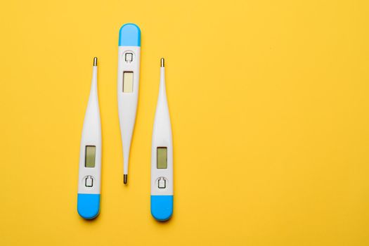 Electronic thermometers . Electronic thermometer on a yellow background. Temperature measurement. Safe thermometer. Modern medical equipment. Science and medicine. Article about safe thermometers. Technologies. Yellow background . Copy space