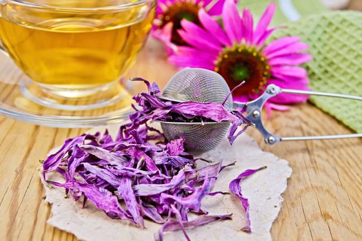 Echinacea dried in a metal strainer and paper, fresh Echinacea flowers on a wooden boards background