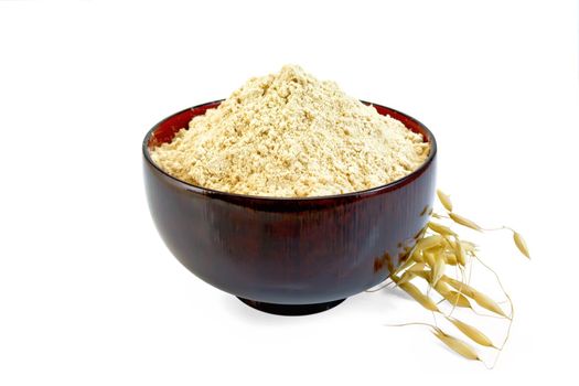 Flour oat in wooden bowl, oaten spike isolated on white background