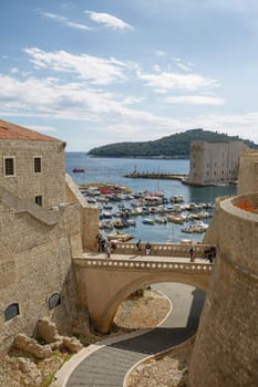 DUBROVNIK, CROATIA - OCTOBER 10, 2017: Port and tourists viewed through fortress walls in Dubrovnik, Croatia