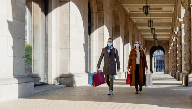 Couple doing their Christmas shopping wearing face masks downtown