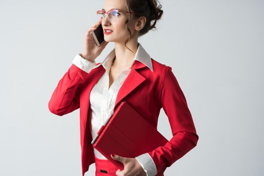 Businesswoman in red suit on the phone