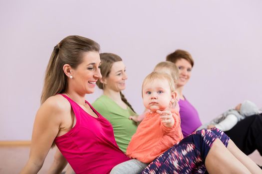 Mothers exercising with their babies at postnatal exercise course