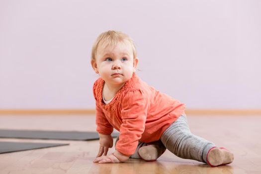 Toddler sitting on floor in gym