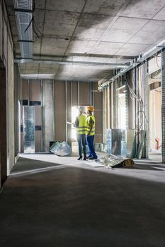 Interior construction works in a building being inspected by two workers