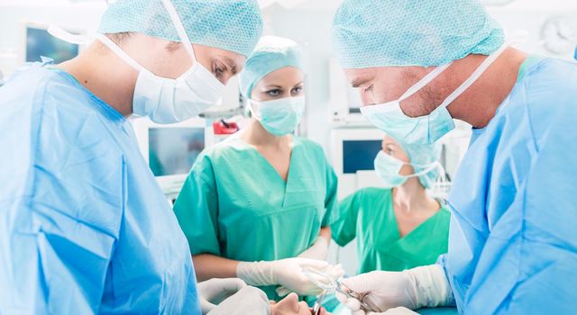 Hospital - surgery team in the operating room or Op of a clinic operating on a patient, perhaps it's an emergency