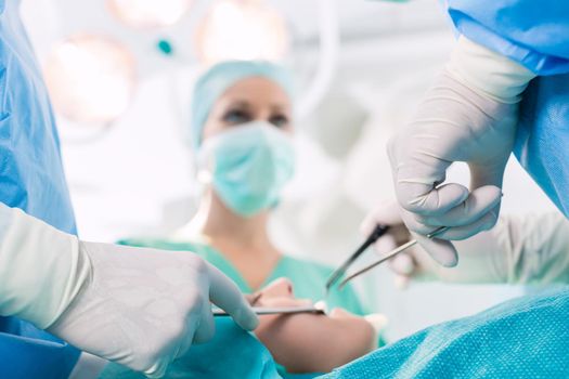 Surgeons operating patient in operation theater at hospital