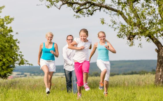Mother and daughters rollerblading with in-line skates on country lane