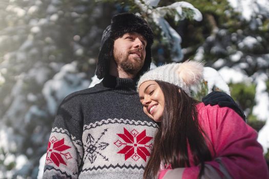 Beautiful romantic woman smiling and lying on the man chest in winter season