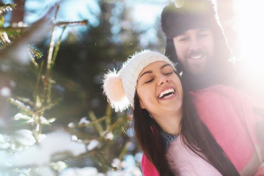 Closeup of happy couple enjoying holiday in winter forest