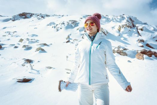 Cheerful woman enjoying a hike on her winter holidays in the snow