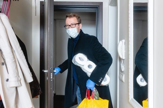 Man wearing medical mask coming home from shopping and hoarding with toilet paper