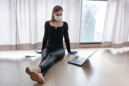 Woman in corona quarantine doing home office sitting by the window