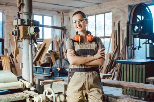 Beautiful proud woman carpenter in her woodwork workshop