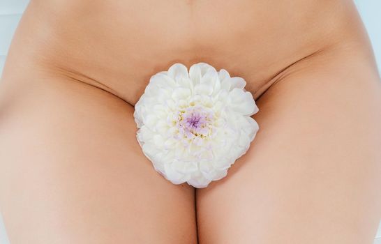 Concept picture for pubic hair removal, woman with flower