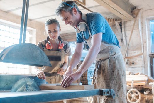 Team of diligent carpenters working on the circular saw