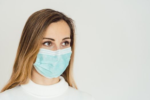 Anxious woman with face mask worried about the Covid-19 outbreak staying at home