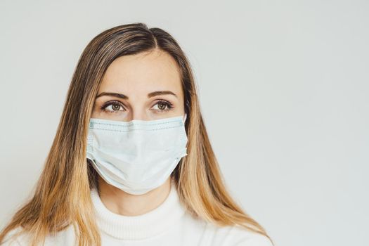 Anxious woman with face mask worried about the Covid-19 outbreak staying at home