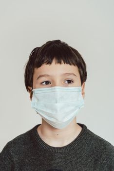 Young boy wearing face mask during Covid-19 crisis staying at home