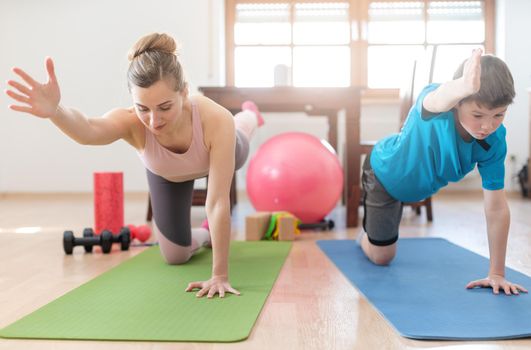 Mother and son in coronavirus quarantine having fitness workout at home