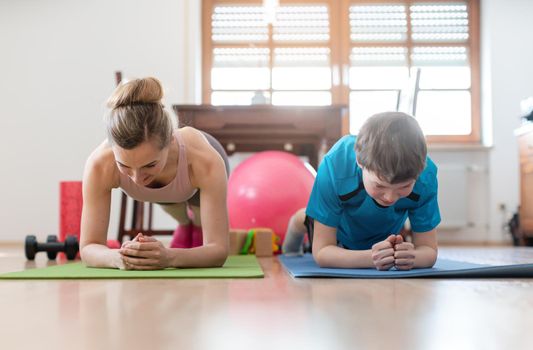 Family in self quarantine during Covid-19 crisis staying fit at home exercising in the living room