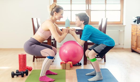 Family doing squats on floor at home during Covid 19 curfew in their home