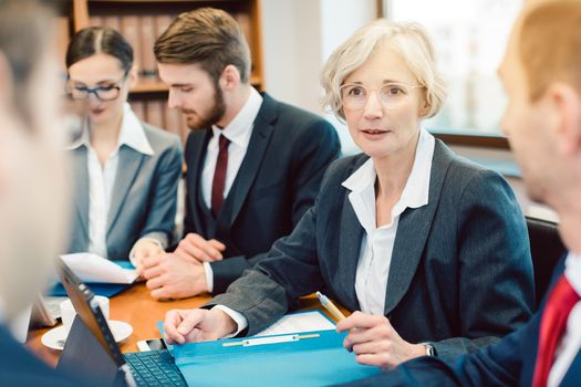 Business team working on some exciting project with computers and documents