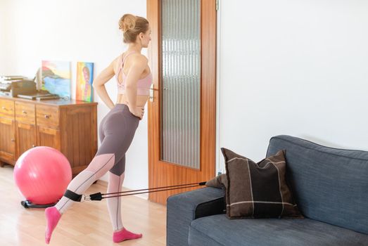 Beautiful woman staying fit during quarantine doing fitness exercise at home