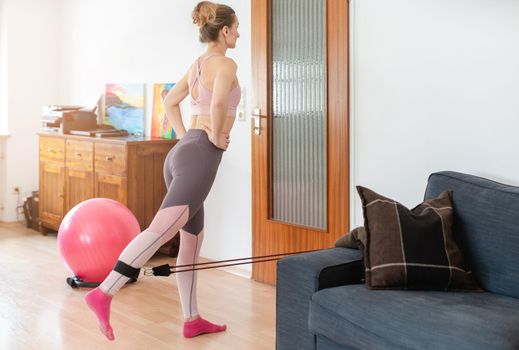 Beautiful woman staying fit during quarantine doing fitness exercise at home