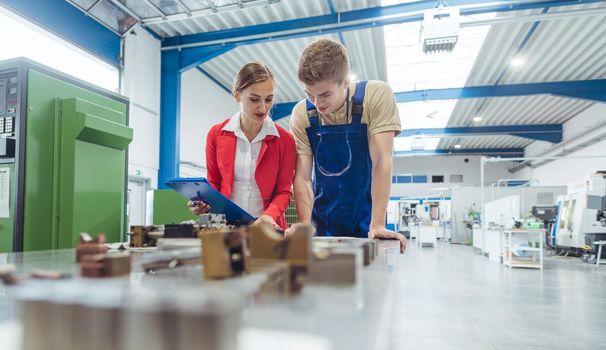 Manufacturing worker and manager during quality inspection of work piece