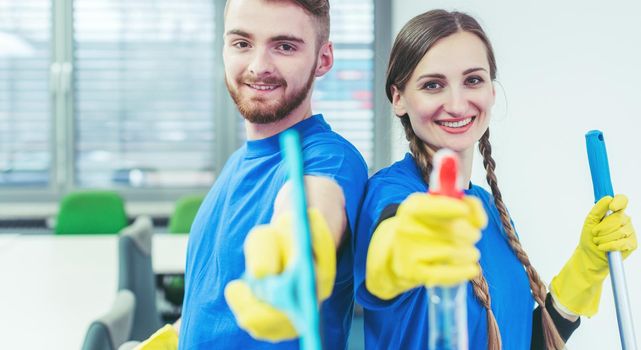 Woman and man in commercial cleaner team doing their job