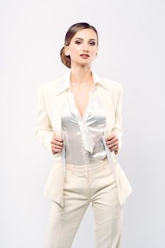 Elegant and fashionable business woman in a white suit, studio shot